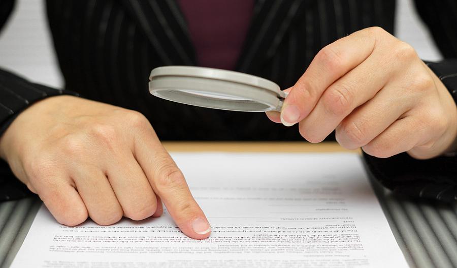 Un hombre mirando un documento a través de una lupa