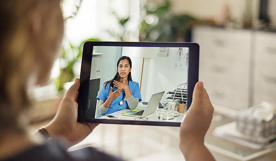 Paciente hablando con un médico usando una tableta digital.