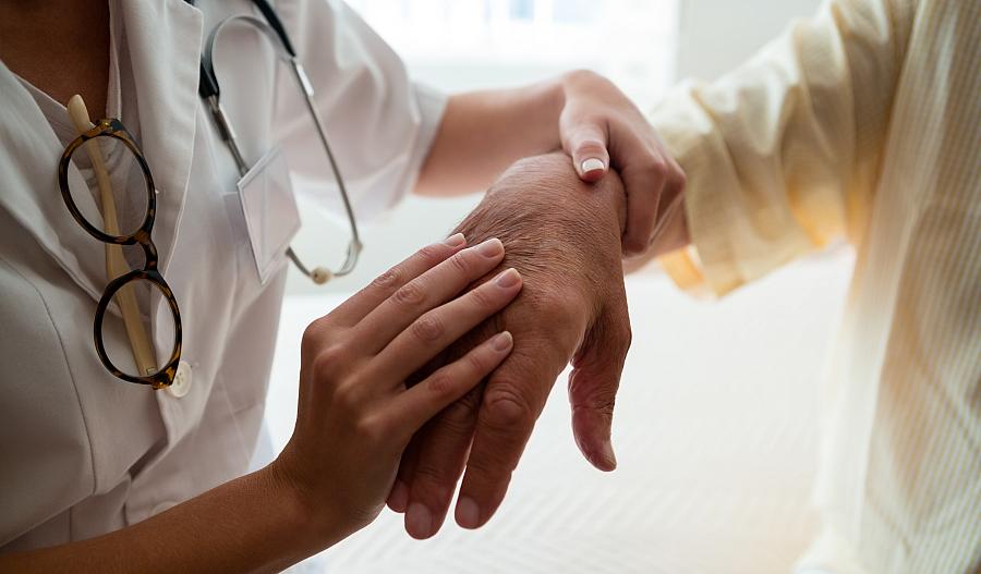 Fotografía de una doctora examinando la mano de un paciente.
